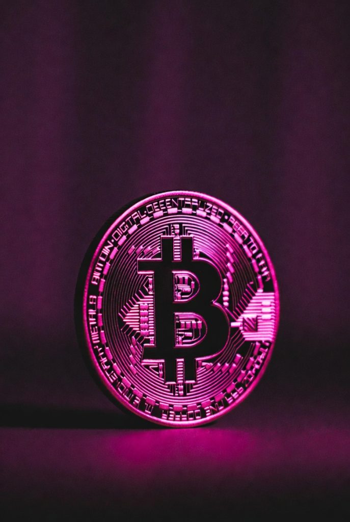 A bitcoin displayed in pink light representing WenCrypto's focus on crypto prop trading.