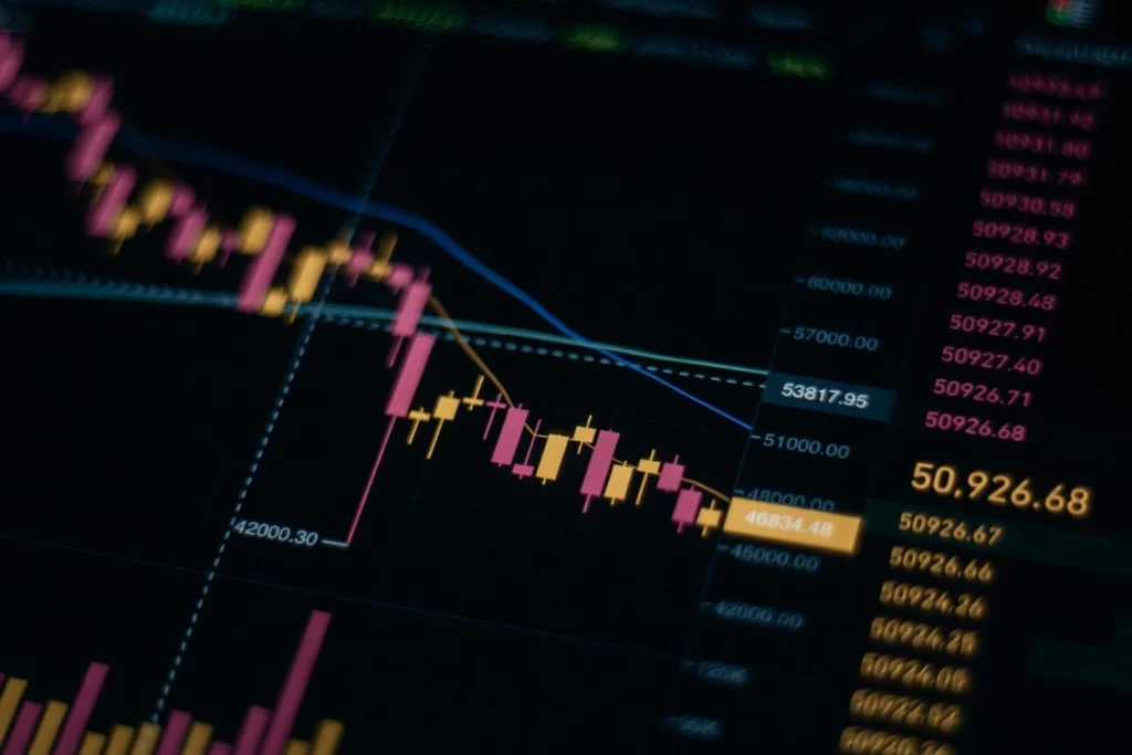 Close-up of a crypto market volatility chart showing sharp price swings with pink and yellow candlesticks on a dark trading screen.